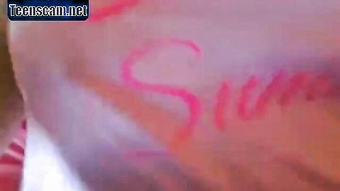 Slim written in pink marker on pale skin in blurry teencam.net webcam closeup