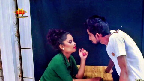 Desi woman in green top whispers intimately to man in white shirt in hot Gi-go-lo scene