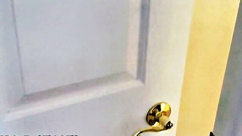 Shiny gold doorknob on white door in bright hallway