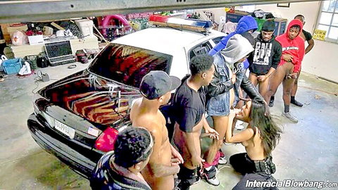 Skinny tanned Latina teen kneels in garage surrounded by black men with big cocks out for interracial blowbang