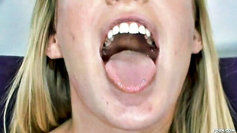 Blonde babe sticks out pink tongue with wide open mouth showing teeth teasing blowjob