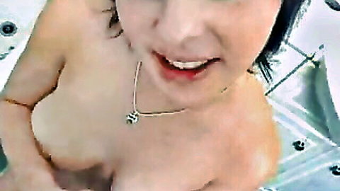 Smiling brunette with big nude tits and long hair in jacuzzi POV closeup