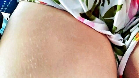 Amateur woman teases body on bus in floral dress, exposing thighs