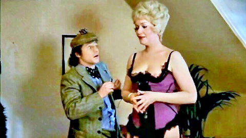 Busty blonde in purple lace bustier showing massive tits flirts with suited man in vintage scene