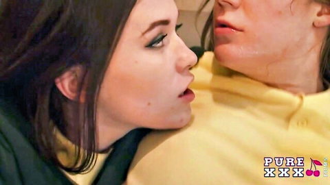 Two young lesbians passionately French kissing with open mouths and tongues touching