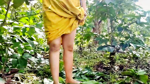 Indian MILF in yellow dress lifting hem outdoors, exposing thighs in forest