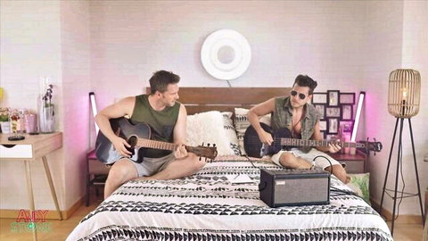 Tru Kait and Andy Stone playing guitars on bed before Latina orgy
