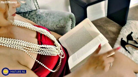 Curvy blonde milf in red dress with pearls, seductive solo reading pose