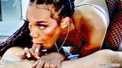 Ebony tgirl with braids sucks thick cock deeply, hand gripping shaft in steamy blowjob