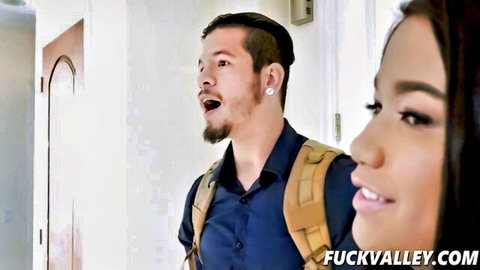 Hot Asian babe smiles seductively next to handsome backpack guy in teasing hallway encounter