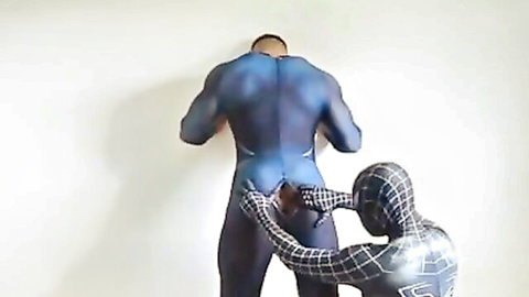 Muscular Superman in blue suit grabbed by Spider-Man in black costume from behind