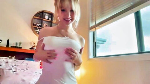Blonde webcam solo babe squeezes her perky tits with nipples visible through thin white top