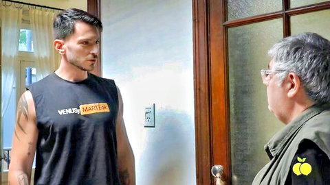 Tattooed hunk in Venus Master tank top confronts older man in green vest by door