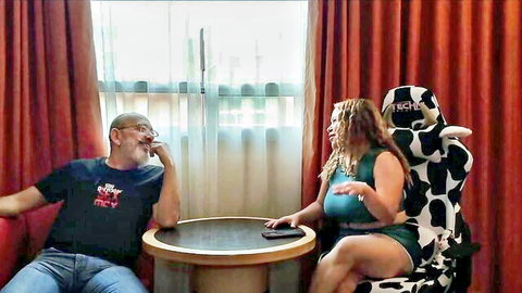 Man interviewing busty curly-haired Latina woman in casual tank top and shorts