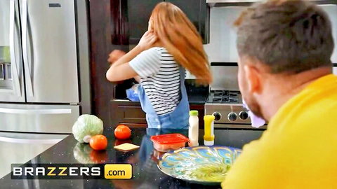 Redhead MILF in striped shirt and shorts cooking salad in kitchen with boyfriend watching