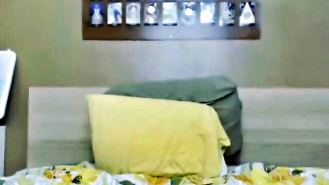 Hot babe lounging on bed with yellow sheets, teasing solo play