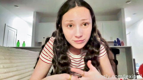 Cute young brunette girlfriend with long wavy hair smiling in striped shirt solo tease