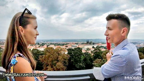 Czech babe in floral dress flirts intimately with handsome guy on Prague balcony overlook