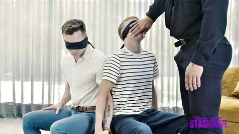 Blindfolded young twinks teased by dominant muscular daddy in gay threesome setup