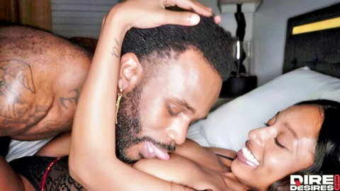 Ebony stud passionately licking smiling black babe's face in bed foreplay