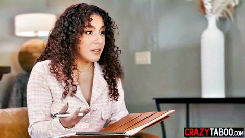 Curly haired brunette in unbuttoned blazer showing deep cleavage while talking seductively