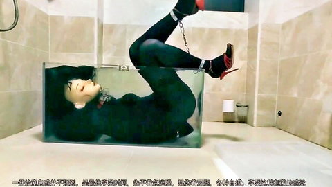 Bound Asian woman chained in water-filled glass tank, black stockings, red heels fetish