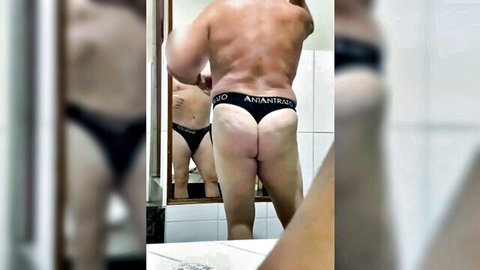 Muscular black daddy in Andrew Christian thong, bathroom mirror pose