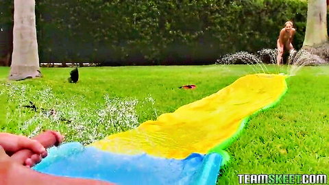 Nude teen girl slides down water slide in garden, outdoor fun tease