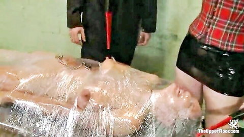 Rain DeGrey bound in plastic wrap during intense BDSM torture