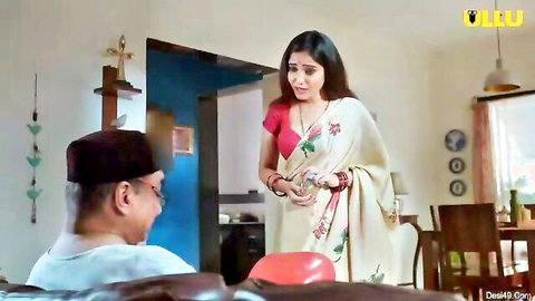 Sexy Indian housewife in white saree stands sensually before older man in home