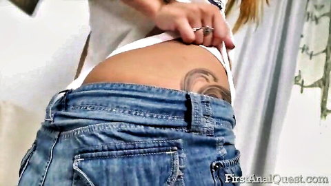 Skinny redhead babe bends over pulling down tight jeans exposing tattooed ass cheeks