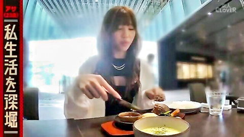Sexy Asian babe with cleavage eating hot soup and rice at restaurant table