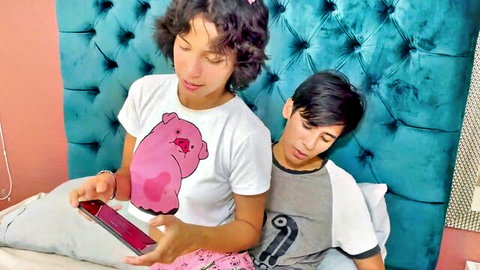 Naughty young stepsister in Peppa Pig tee shows stepbrother phone on bed teasingly