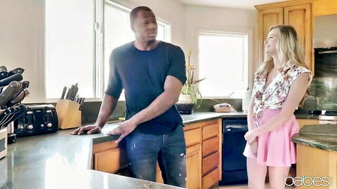 Petite blonde in pink skirt flirts with tall muscular black man in kitchen