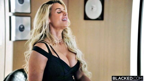 Blonde bombshell with massive tits in black dress moaning in ecstasy
