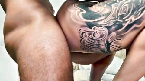 Curvy busty Latina babe with intricate tattoos nude on bed