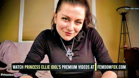 Princess Ellie Idol smiling seductively in black top for The Church Of Satan femdom video