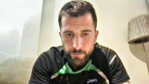 Handsome bearded man in tight black Adidas athletic shirt posing closeup on webcam