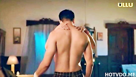 Muscular shirtless Indian man hugged from behind by woman in steamy bedroom