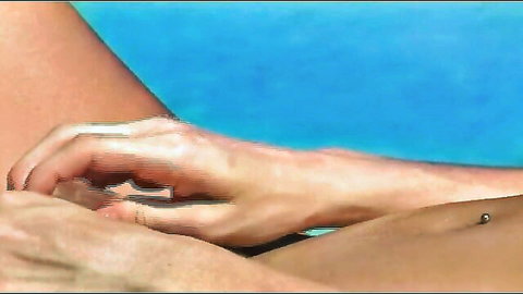 Woman with navel piercing touched intimately on thigh near pool