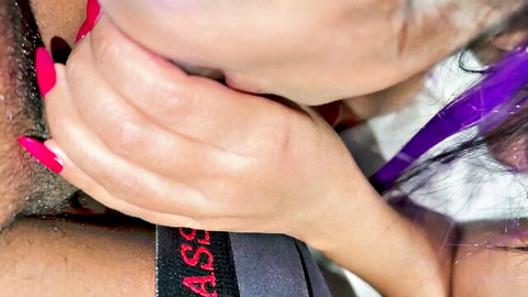 Purple-haired woman with red nails grips man's crotch in intimate close-up