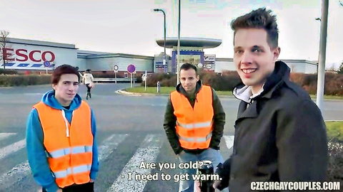 Three Czech guys in hi-vis vests warming up in Tesco parking lot