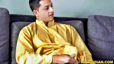 Young Indian man in yellow kurta, teasing gaze on couch