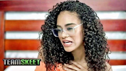 Petite black beauty with curly hair and glasses in teasing pose
