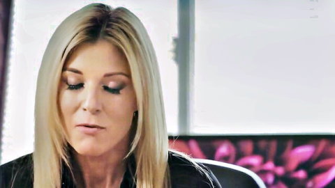 Blonde woman in black top with thoughtful gaze, from I Love Lesbians video