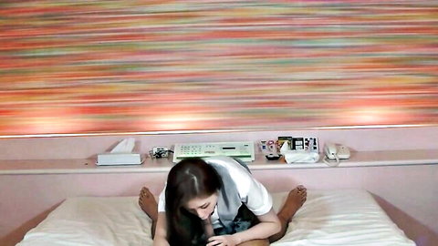 Japanese amateur black-haired schoolgirl in shirt and tie, legs spread on bed