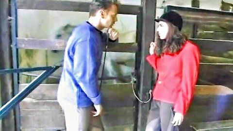 Rocco Siffredi and brunette in red jacket by horse stable
