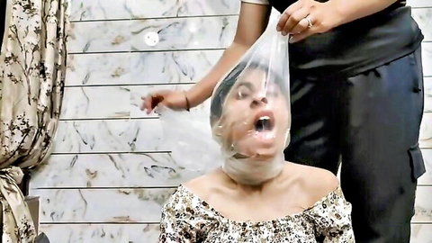 Two women in breath play, one with plastic bag over head, gasping