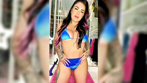 Tattooed curvy Latina in blue bikini posing seductively
