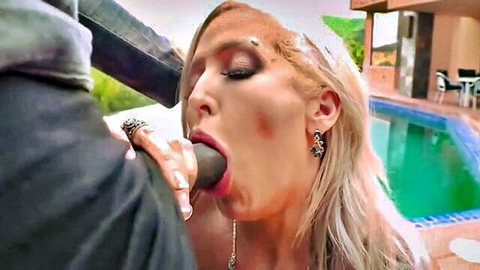 Blonde bombshell with glossy lips slurps huge black cock poolside outdoors